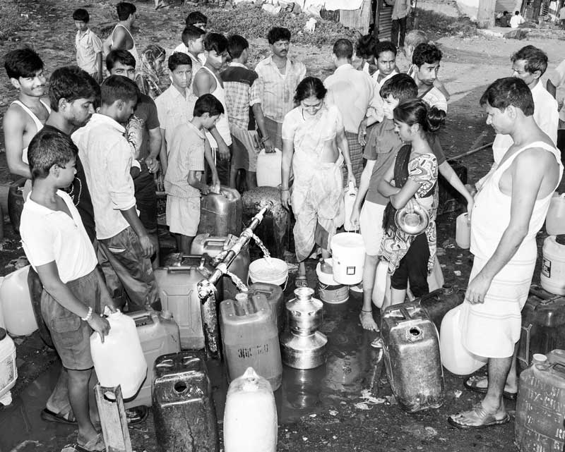 Queue and Rush for Drinking Water - Men, women and children collecting water at their turn from a public standpoint in Mumbai, Maharashtra
